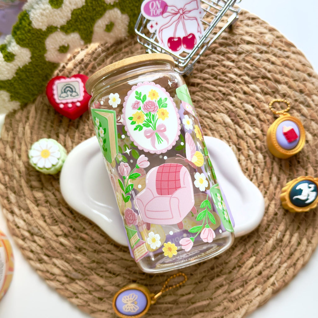 Decorative glass bottle with floral design on a woven mat