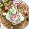 Decorative glass bottle with floral design on a woven mat