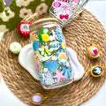 Decorative glass jar with sea-themed stickers on a textured surface with small decorative items around.